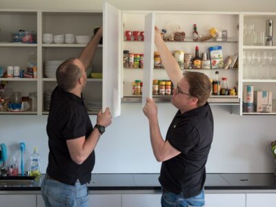 Zwei zweimalig Mitarbeiter beim demontieren von Küchentüren.